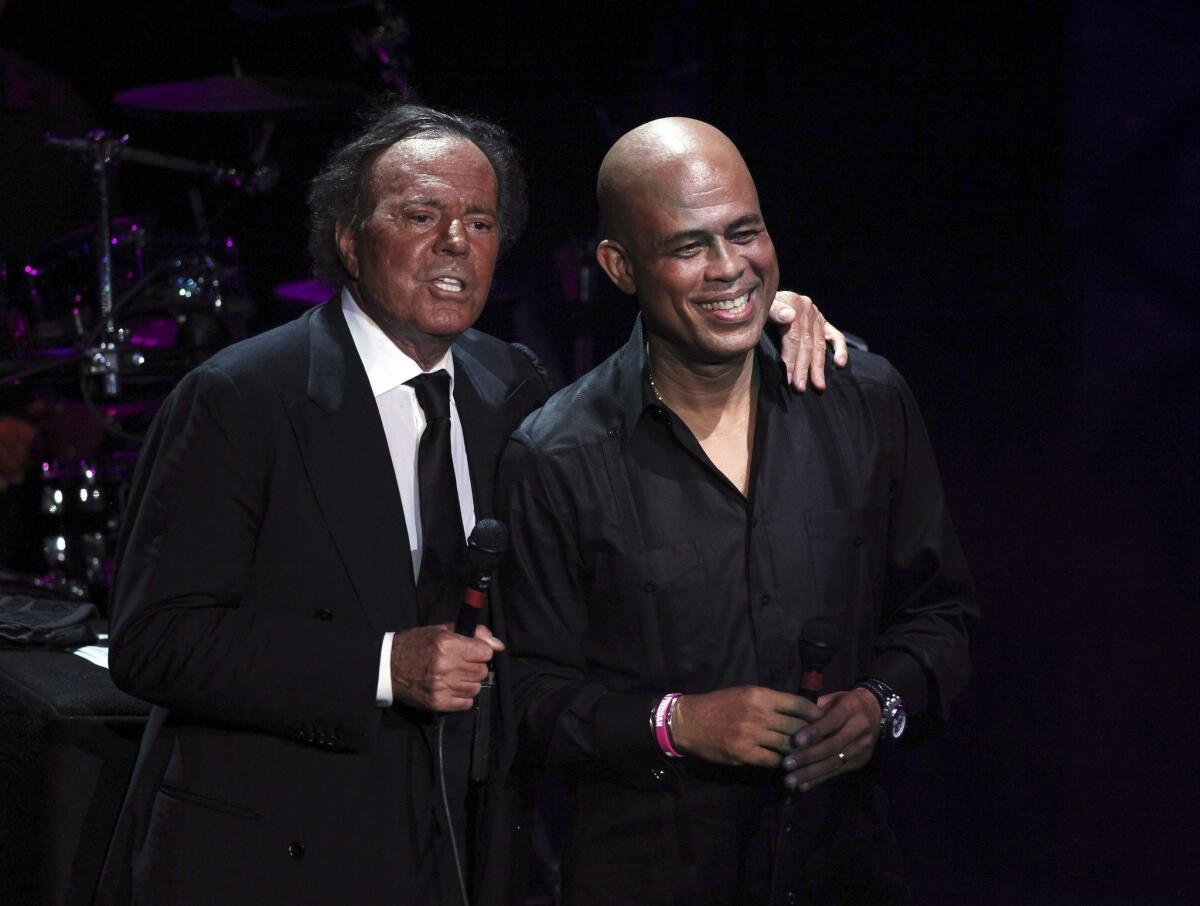 Julio Iglesias, left, is joined onstage by former singer and current president of Haiti Michel Martelly during a charity concert in the Dominican Republic last December.