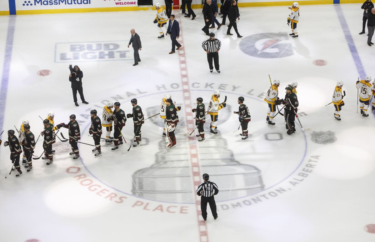 Nashville Predators and the Arizona Coyotes shake hands following overtime in an NHL hockey playoff game Friday, Aug. 7, 2020, in Edmonton, Alberta. (Jason Franson/Canadian Press via AP)