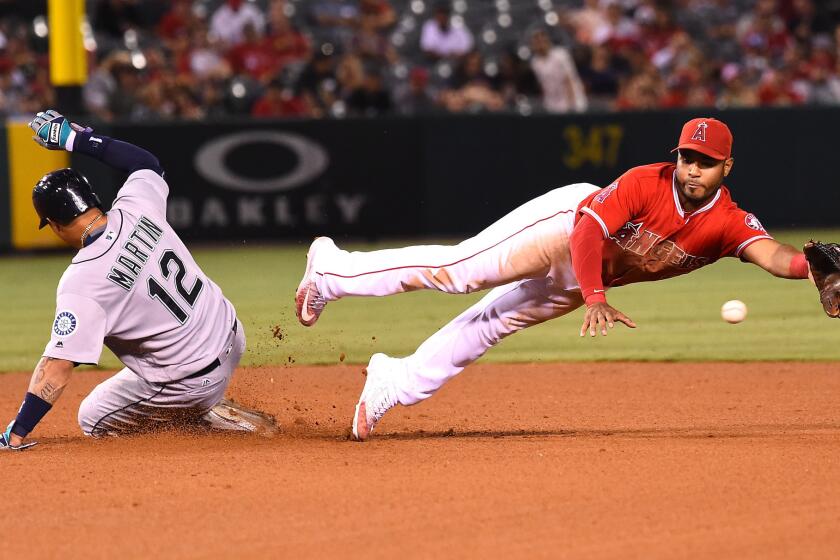 Angels infielder Gregorio Petit reaches for a wide throw as Mariners outfielder Leonys Martin (12) slides in safelly with a stolen base in the fourth inning.