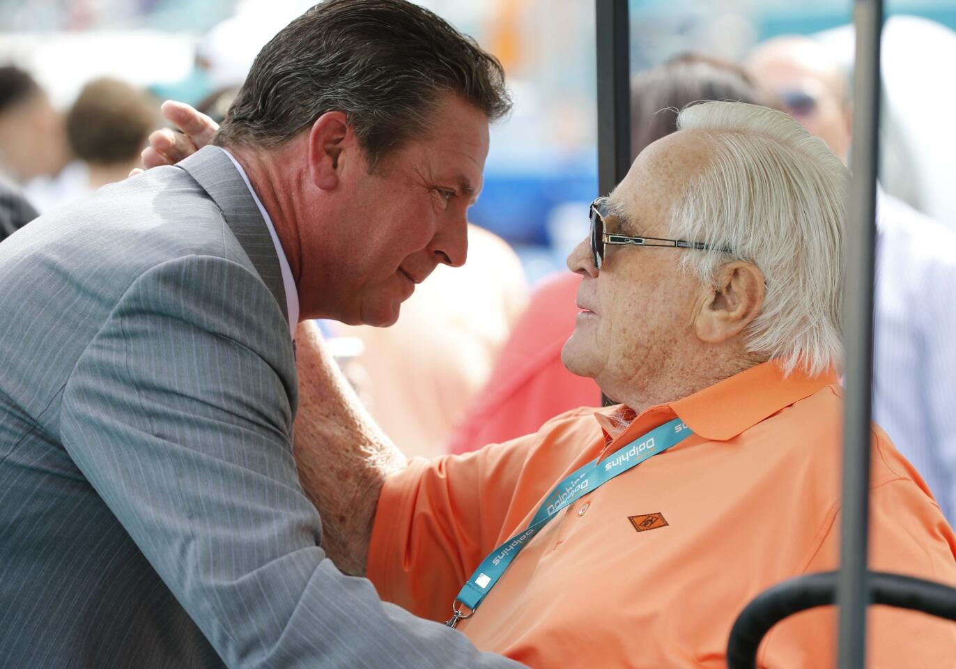 Former Miami Dolphins quarterback Dan Marino, left, greets former head coach Don Shula on the field before an NFL football game against the New England Patriots, Sunday, Jan. 3, 2016 in Miami Gardens, Fla. (AP Photo/Wilfredo Lee)