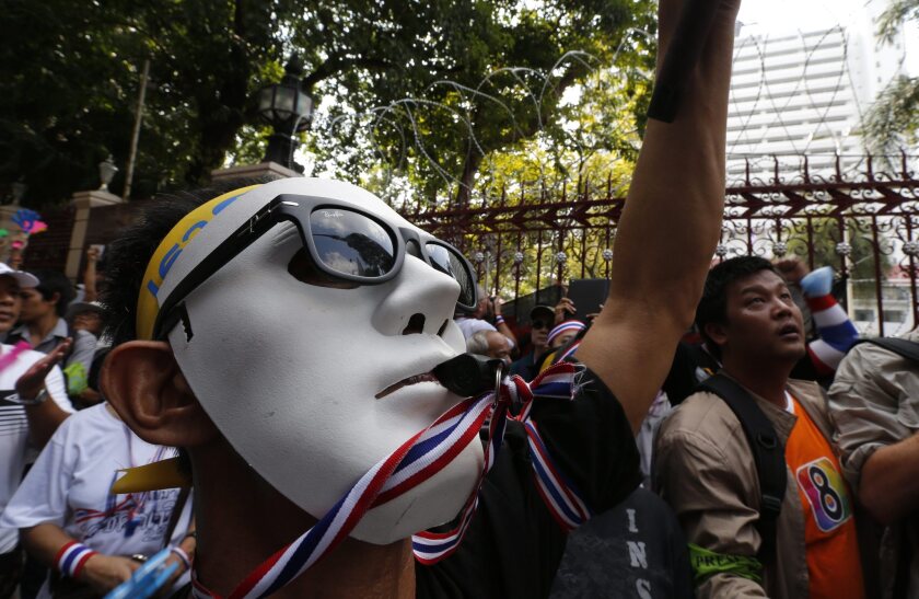 Anti-government protester wearing a mask and blowing a whistle protests outside the Royal Thai Police Headquarters in Bangkok, Thailand, on Sunday.
