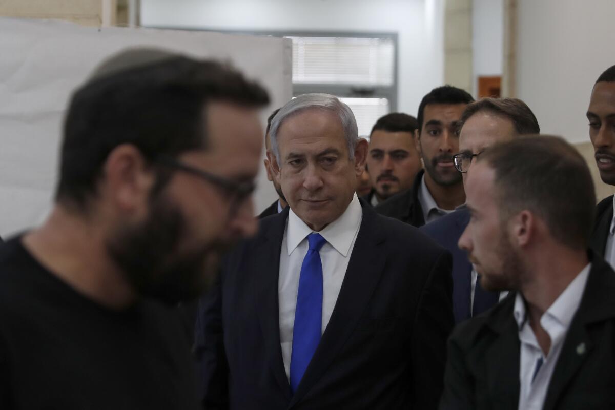 Benjamin Netanyahu walks down a hall.