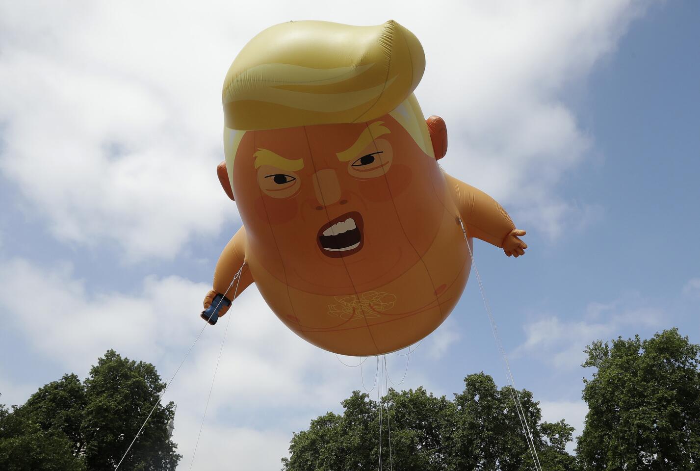 A six-meter high cartoon baby blimp of U.S. President Donald Trump is flown as a protest against his visit, in Parliament Square in London, England, Friday, July 13, 2018.