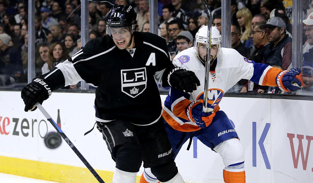 Kings center Anze Kopitar and Islanders defenseman Nick Leddy watch the puck fly into the corner of the rink during the second period Thursday night at Staples Center.