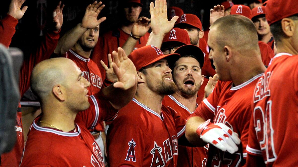 Angels center fielder Mike Trout celebrates with teammates in the dugout after hitting a grand slam against the Twins in the second inning Thursday night.