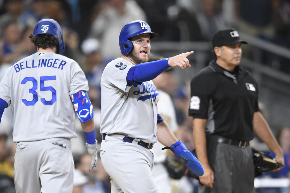 Dodgers' Max Muncy points out to Justin Turner after scoring.