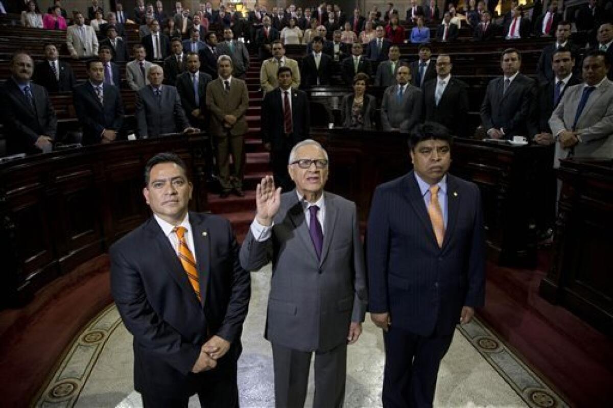 Alejandro Maldonado Aguirre levanta la mano al jurar como nuevo vicepresidente de Guatemala ante el Congreso, el jueves 14 de mayo de 2015. (AP Foto/Moises Castillo)