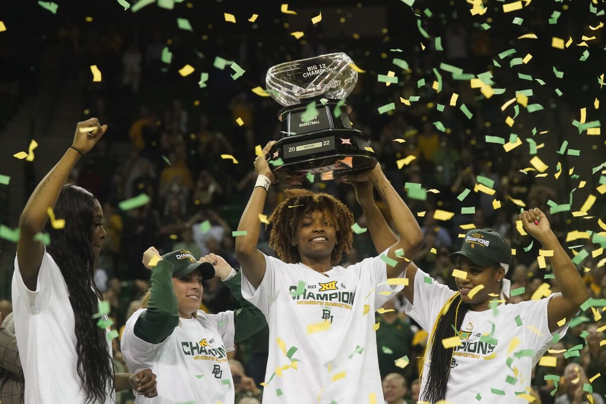Baylor forward NaLyssa Smith, center right, holds up the Big 12 regular season champion trophy with head coach Nicki Collen, center left, and teammates Jordan Lewis, right, and Queen Egbo after an NCAA college basketball game against Texas Tech in Waco, Texas, Sunday, March 6, 2022. (AP Photo/LM Otero)