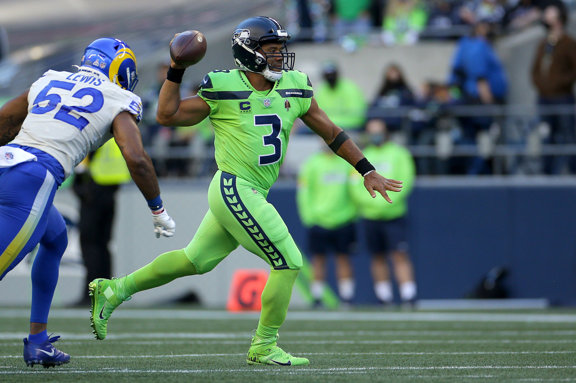 Seattle Seahawks quarterback Russell Wilson passes in front of Rams linebacker Terrell Lewis.