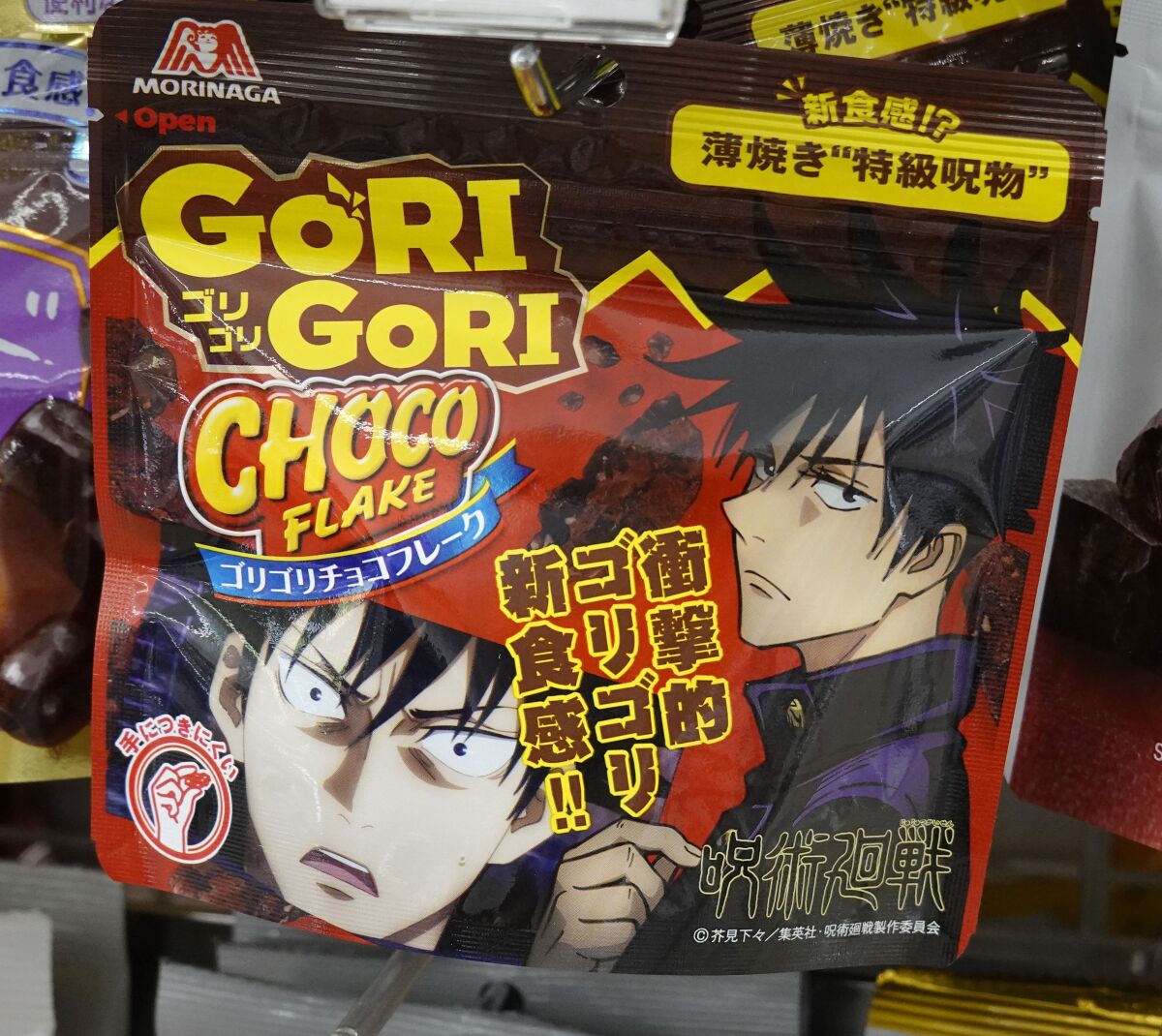 A package with anime characters is labeled "Gori Gori Choco Flake" at a 7-Eleven in Tokyo.