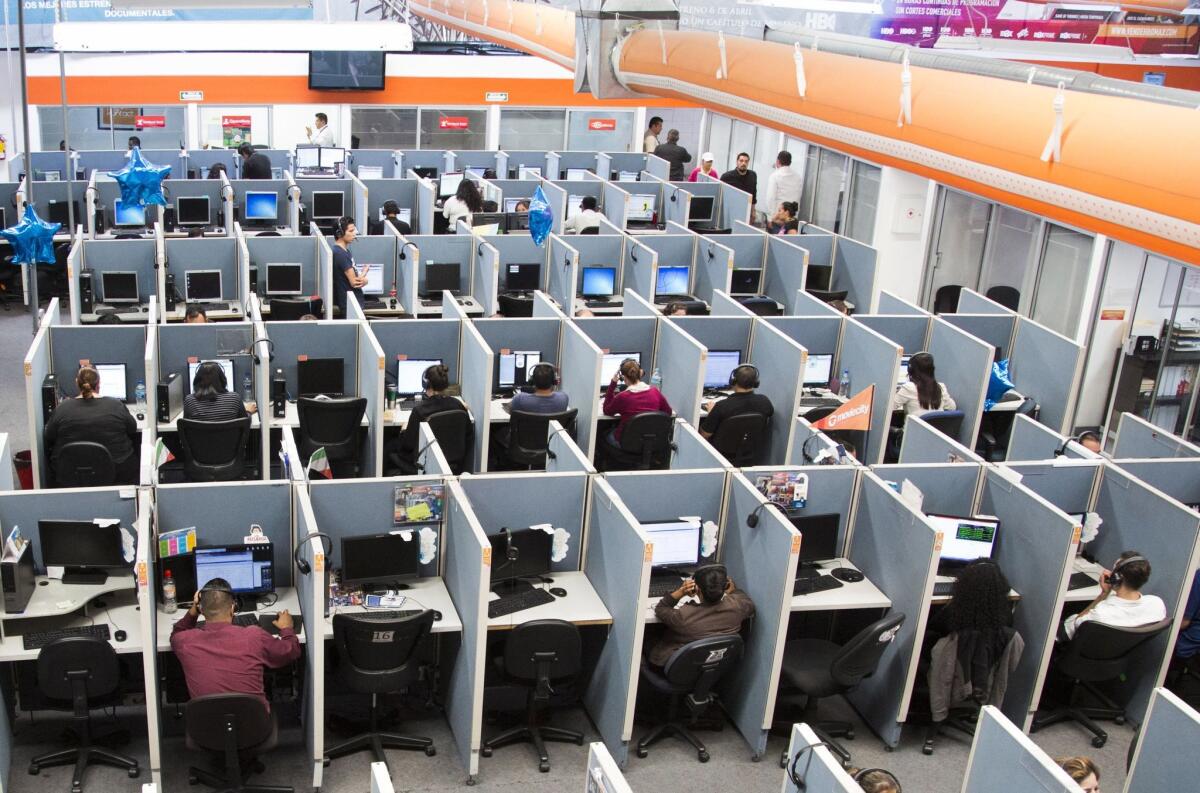 Workers sit at desks at a call center in Tijuana, Mexico. A new study says that sitting for more than seven hours a day may increase your risk of premature death, as may insufficient sleep and more traditional risk factors.