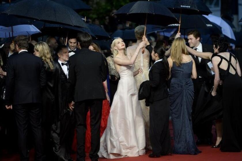 British actress Carey Mulligan, in white, holds an umbrella as she arrives for the screening of the "The Great Gatsby" at the Cannes Film Festival.