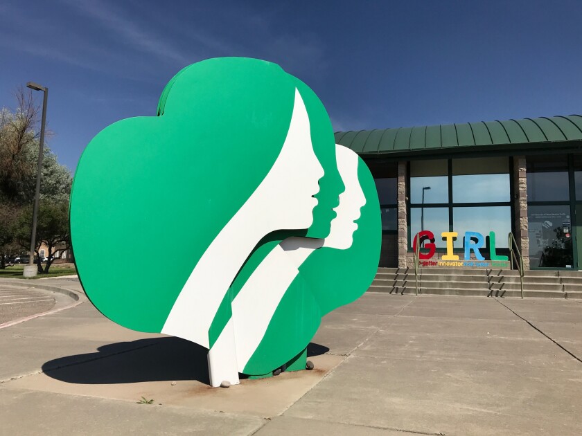 An outdoor artwork shows the Girl Scout logo, three girls' faces in silhouette, in Albuquerque.