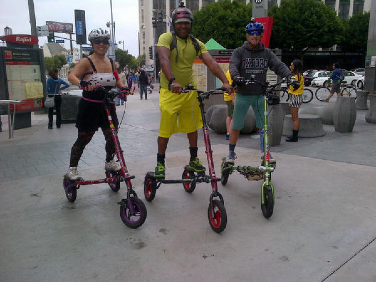 Monica Jeffries, 40, and Quincy Jeffries, 42, of Canyon Country, and their friend. Dennis Hauswirth, 62, of Brentwood, ride their trikkes during CicLAvia on Wilshire Boulevard. (Hailey Branson-Potts/LA Times.)