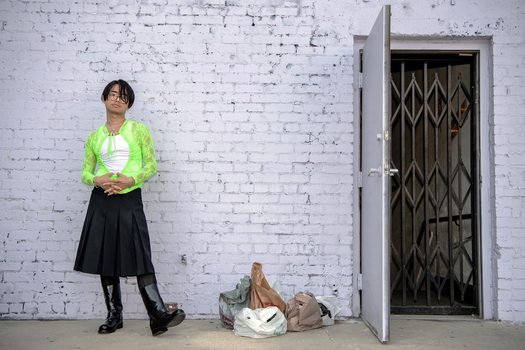 Shaojun Chen outside a warehouse in a bright green Hanes tank top