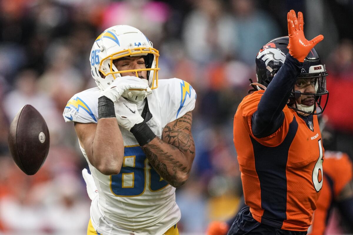 Chargers wide receiver Keelan Doss (86) drops a pass as Broncos safety P.J. Locke (6) defends.