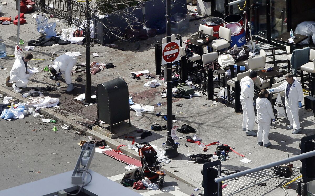 FILE - In this April 16, 2013, file photo, investigators examine the scene of the second bombing outside the Forum Restaurant on Boylston Street near the finish line of the 2013 Boston Marathon, a day after two blasts killed three and injured more than 260 people. The Biden administration's argument at the Supreme Court for reinstating the death penalty for convicted Boston Marathon bomber Dzhokhar Tsarnaev hinges on keeping evidence from the jury that prosecutors themselves relied on at an earlier phase of the proceedings. (AP Photo/Elise Amendola, File)