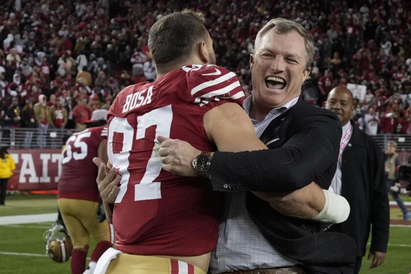 San Francisco 49ers defensive end Nick Bosa (97) celebrates with general manager John Lynch after an NFL divisional round playoff football game against the Dallas Cowboys in Santa Clara, Calif., Sunday, Jan. 22, 2023. (AP Photo/Tony Avelar)