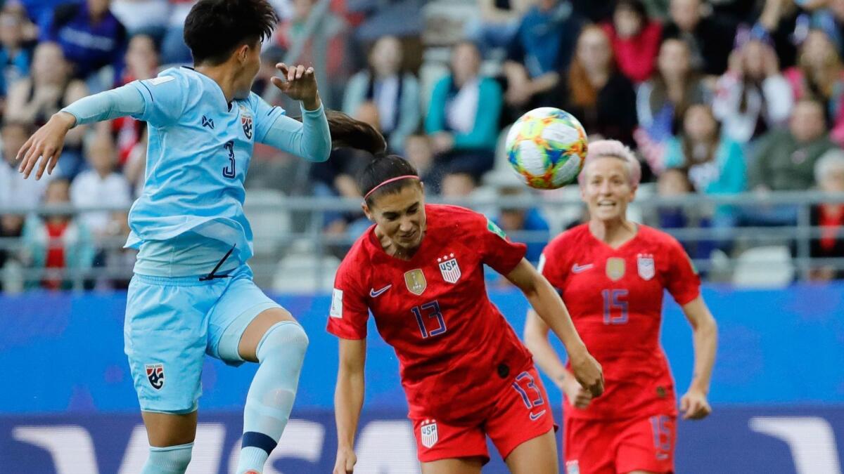 Alex Morgan heads the ball and scores the opening goal against Thailand.