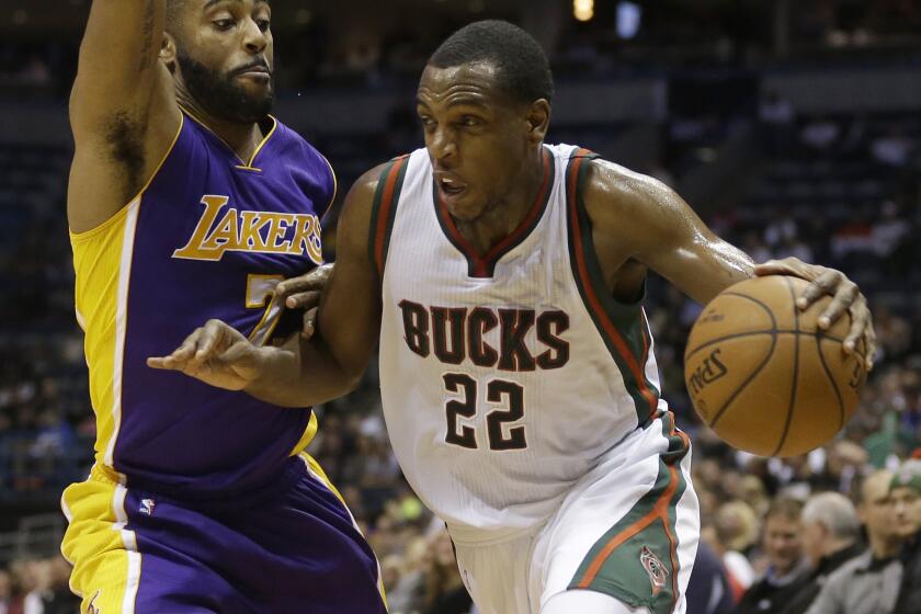 Milwaukee guard Khris Middleton drives past Wayne Ellington during a game on Feb. 4. The Lakers lost to the Bucks, 113-105, in overtime.