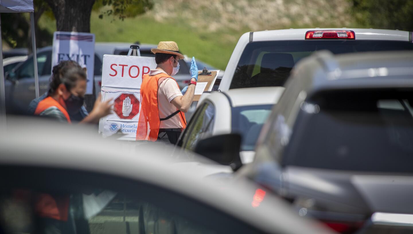 A small line of cars waits as U.S. citizenship officer Newton Perez administers the oath of allegiance.