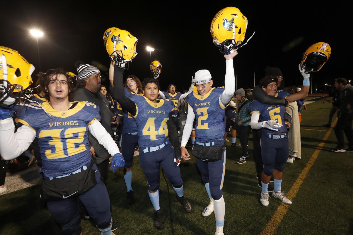 Marina's Owen Strampello (32), Edwin Eguizabal (44), Gavin Del Toro (2) and Pharoah Rush (6) celebrate with teammates after defeating Muir 18-9 in the CIF Southern Section Division 11 title game on Friday at Westminster High.