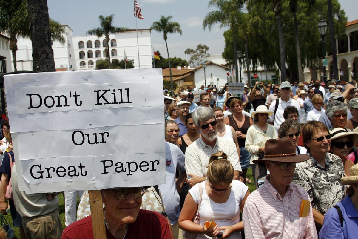 Protesters gather, one holding sign that reads 'Don't kill our great paper'