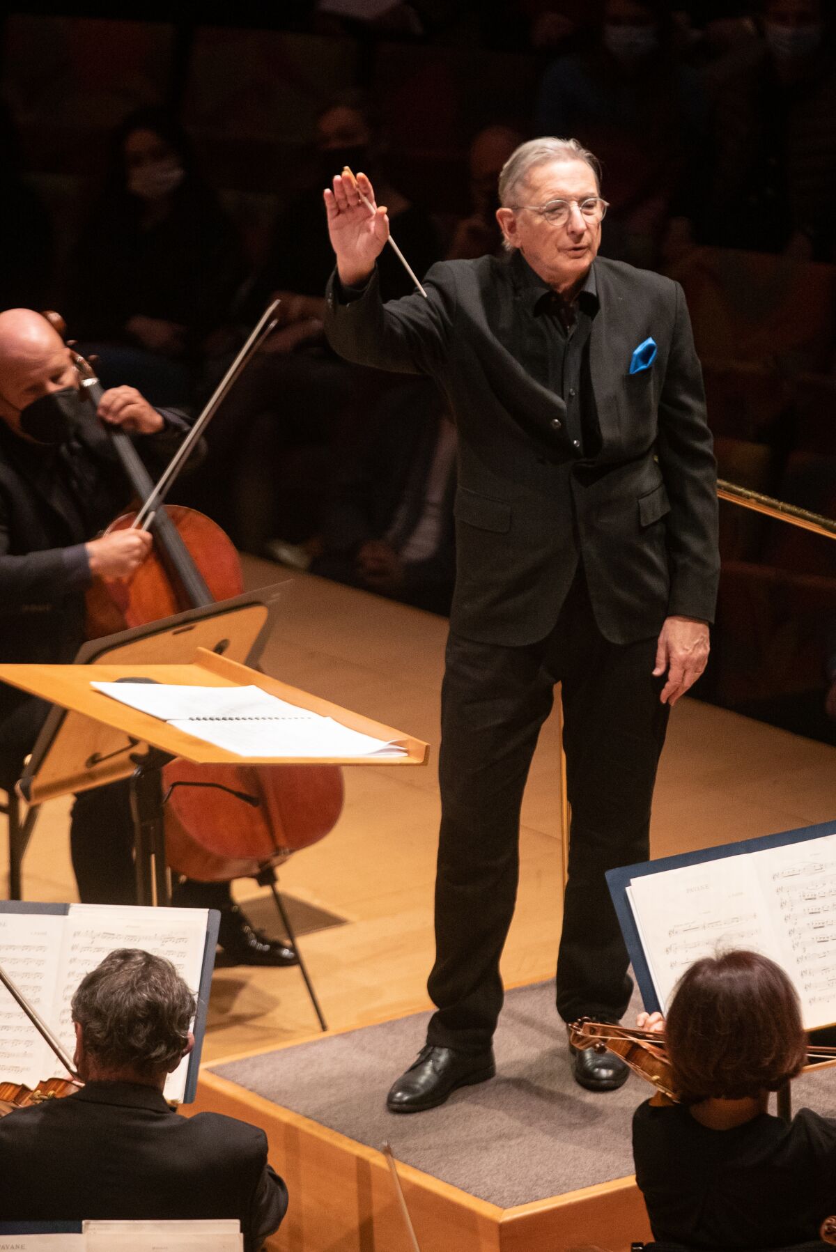 Michael Tilson Thomas is seen waving from atop the conductor's podium at Disney Hall.