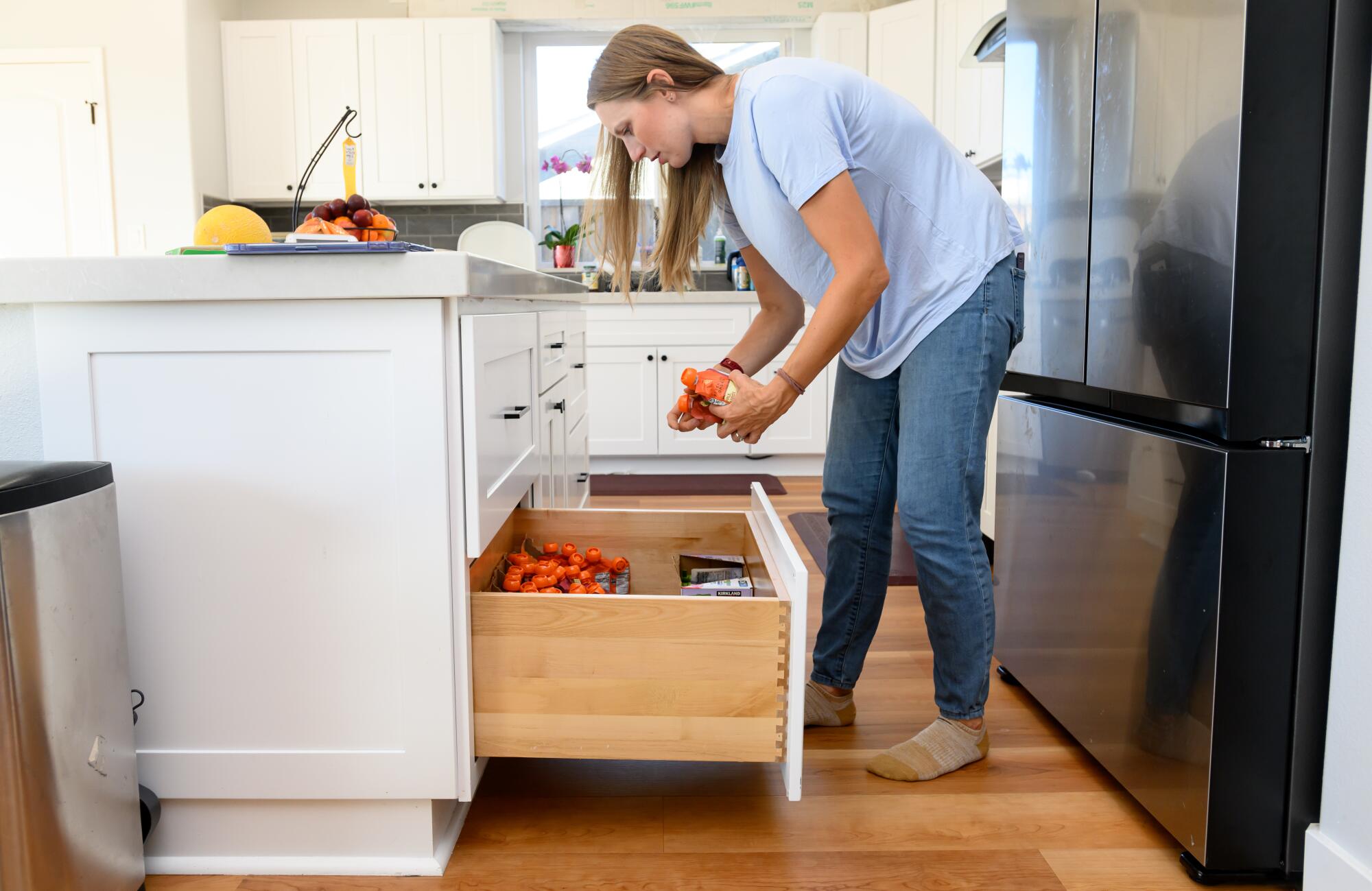 A woman leans toward a drawer filled with pouches