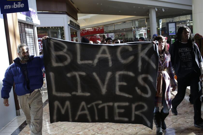 Demonstrators protesting the shooting death of Michael Brown in nearby Ferguson march through the Galleria Mall in St. Louis, yelling slogans to the Black Friday crowd.