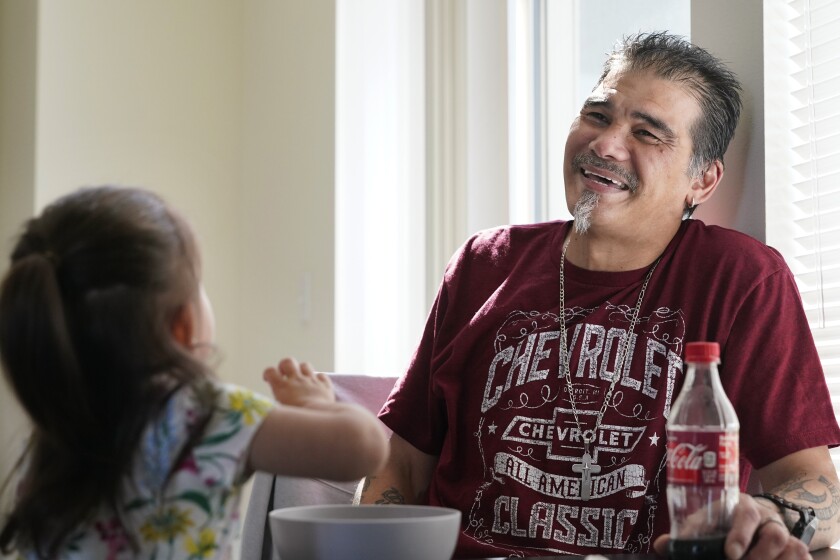 Leroy Pascubillo smiles as he looks at his daughter, who was born addicted to heroin and placed with a foster family at birth, and talks about his journey regaining custody, May 10, 2021, in Seattle. Pascubillo, who had used drugs for the better part of four decades, was in a court-ordered in-patient drug rehab program when the pandemic first hit. (AP Photo/Elaine Thompson)