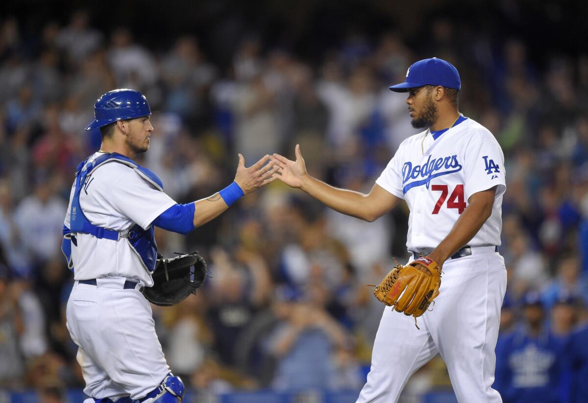 Dodgers catcher Yasmani Grandal, left, congratulates closer Kenley Jansen after he earned his 15th save of the season in a 3-2 win over the Brewers on July 10 at Dodger Stadium.