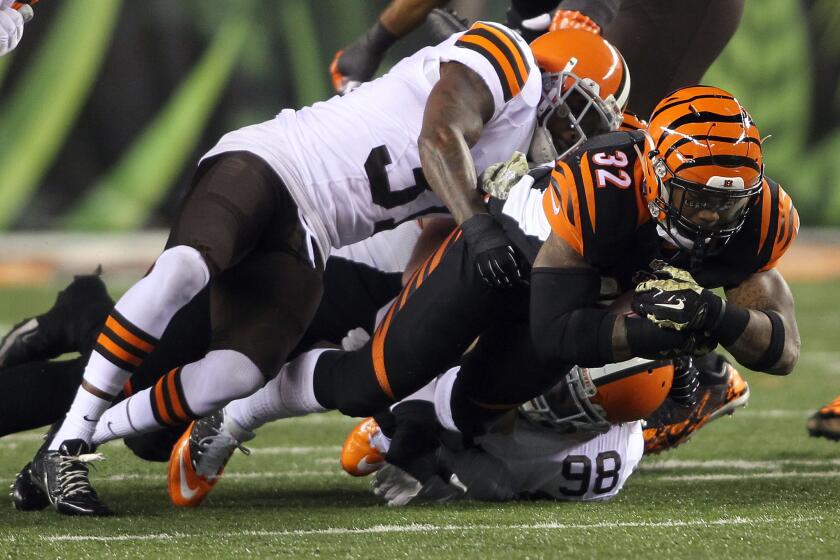 Cincinnati running back Jeremy Hill (32) is tackled by Cleveland's Dontae Whitner, top, and Phil Taylor.