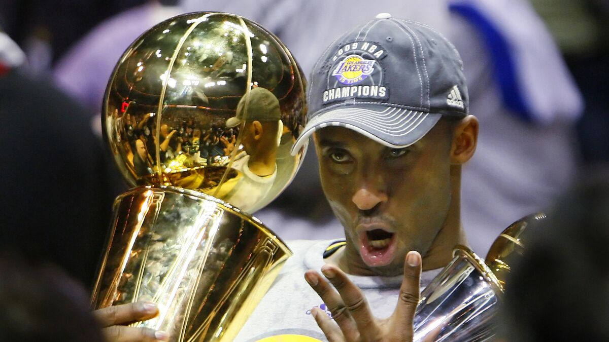 Lakers guard Kobe Bryant holds the Larry O'Brien Trophy while celebrating his NBA fourth championship.