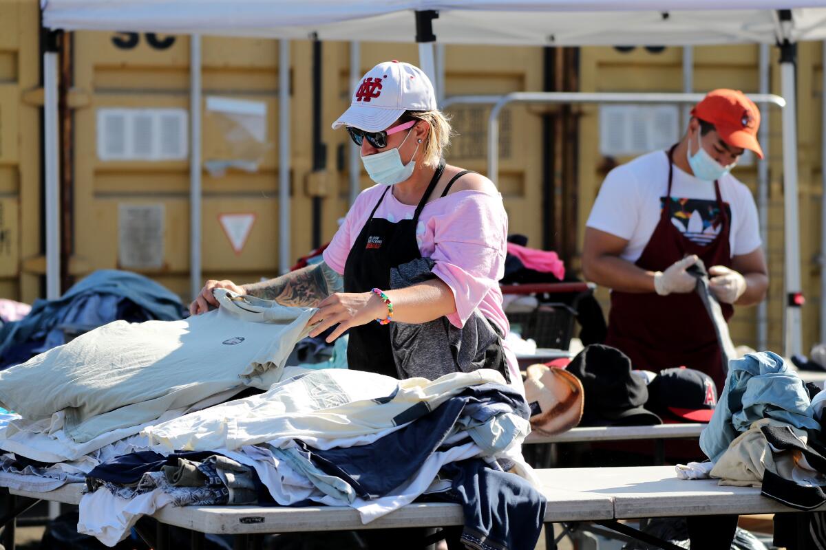 Mary's Kitchen volunteer Melissa Welsh sorts clothing by size for people who need it.