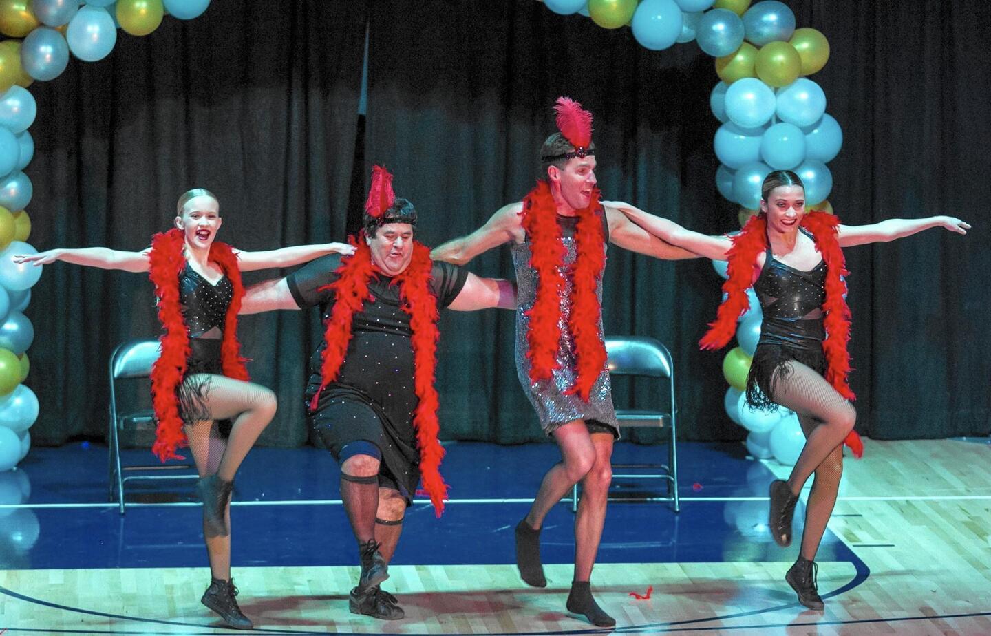 Bella Swart, Ed Bell, John Brazelton and Karson Speth, from left, of team “Brazzle DazzlEd” perform during the sixth annual Dancing with the Staff event at Newport Harbor High School on Thursday.