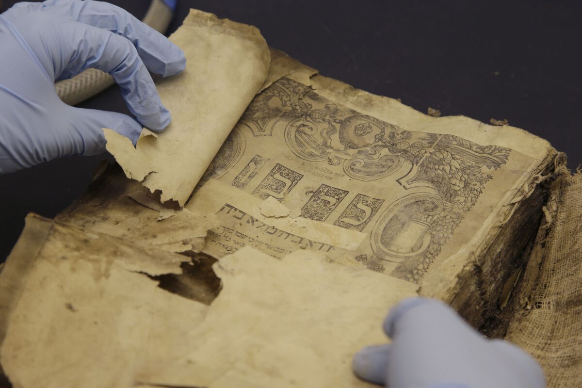 A librarian holds a copy of the Kol Bo from the 1540s, one of the Iraqi Jewish documents conserved at the National Archives in College Park, Md.