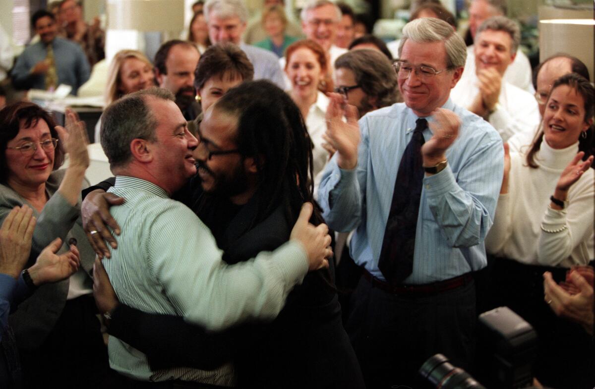 Clarence Williams III, right, is congratulated by Michael Parks on April 14, 1998, after winning a Pulitzer Prize.