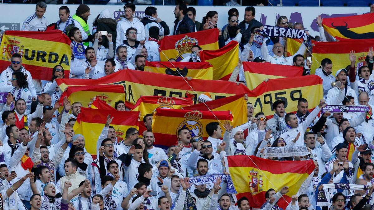 Real Madrid fans hold up Spanish national flags before the start of the Spanish La Liga soccer match between Real Madrid and Barcelona at the Santiago Bernabéu stadium in Madrid on Dec. 23, 2017.