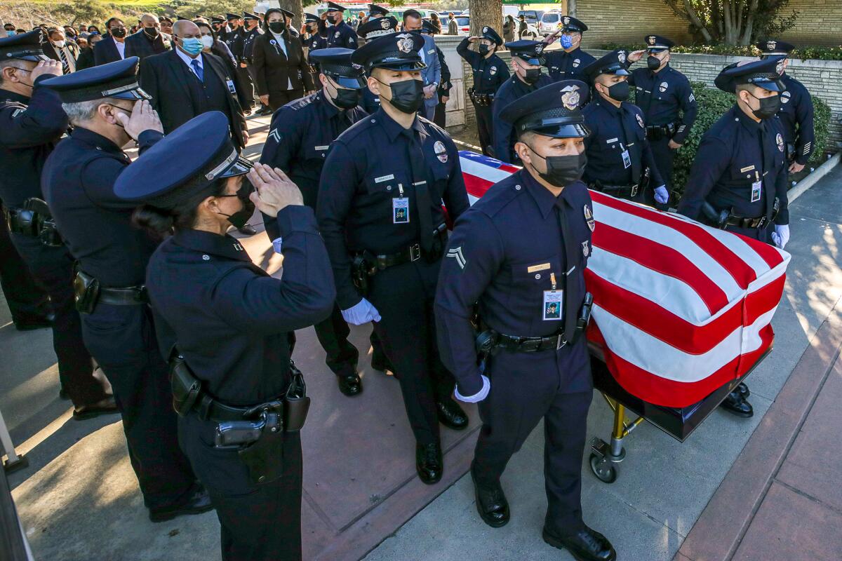 Pallbearers carry the casket of LAPD Officer Fernando Arroyos at Forest Lawn-Hollywood Hills.