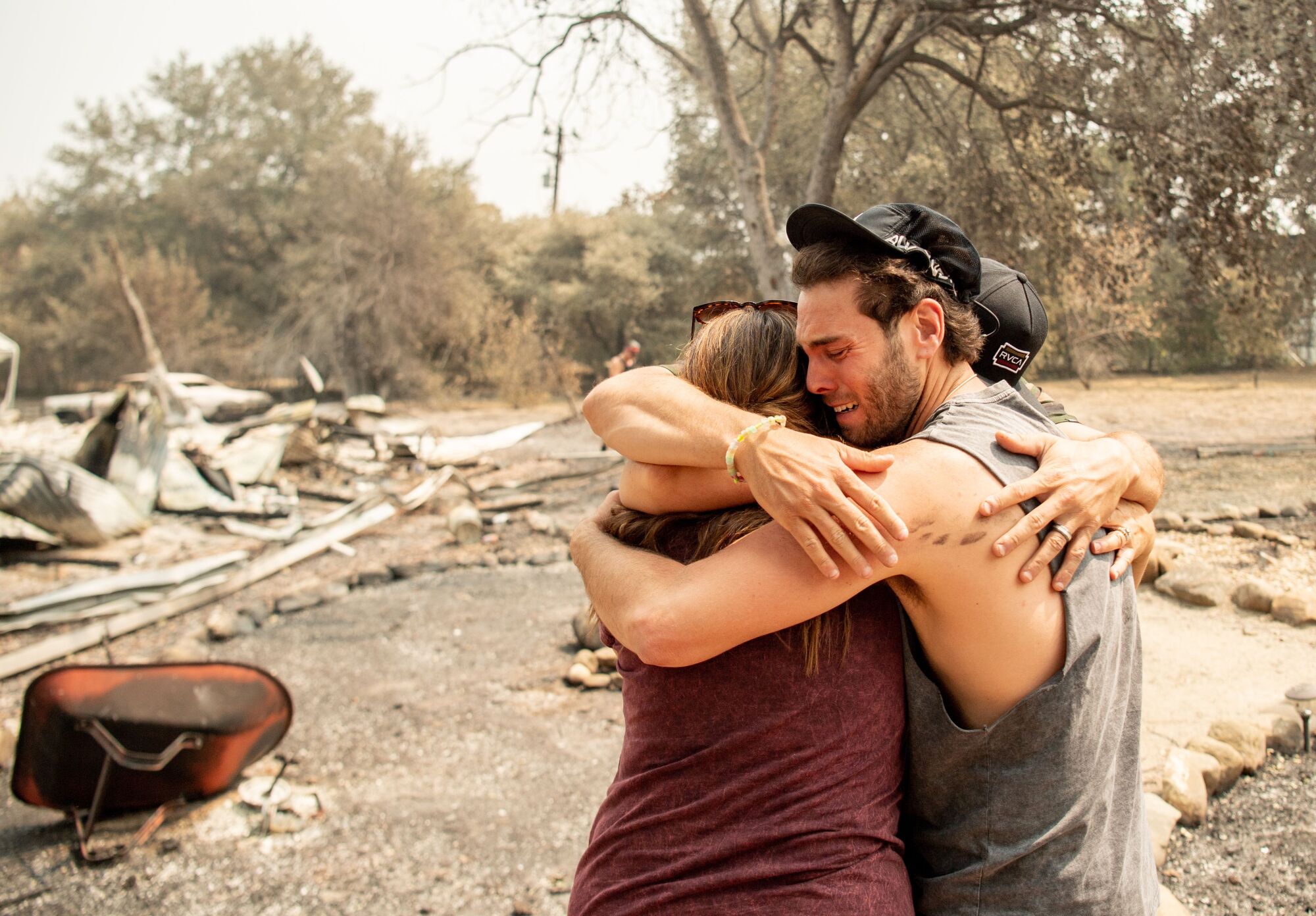Family members embrace at the burned remains of their home in Vacaville, Calif.