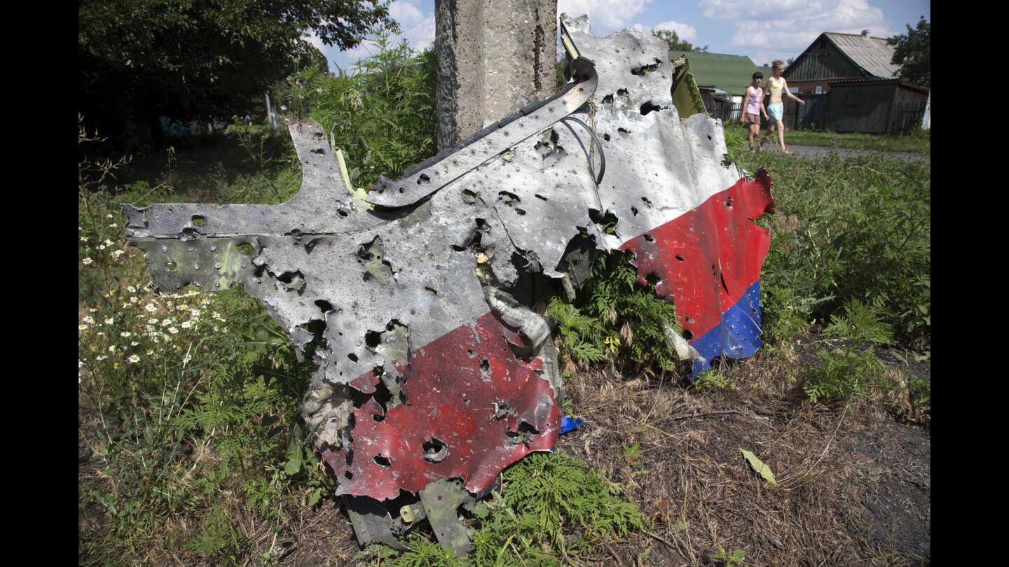 Children walk past a piece of the wreckage in the village of Petropavlivka in eastern Ukraine.