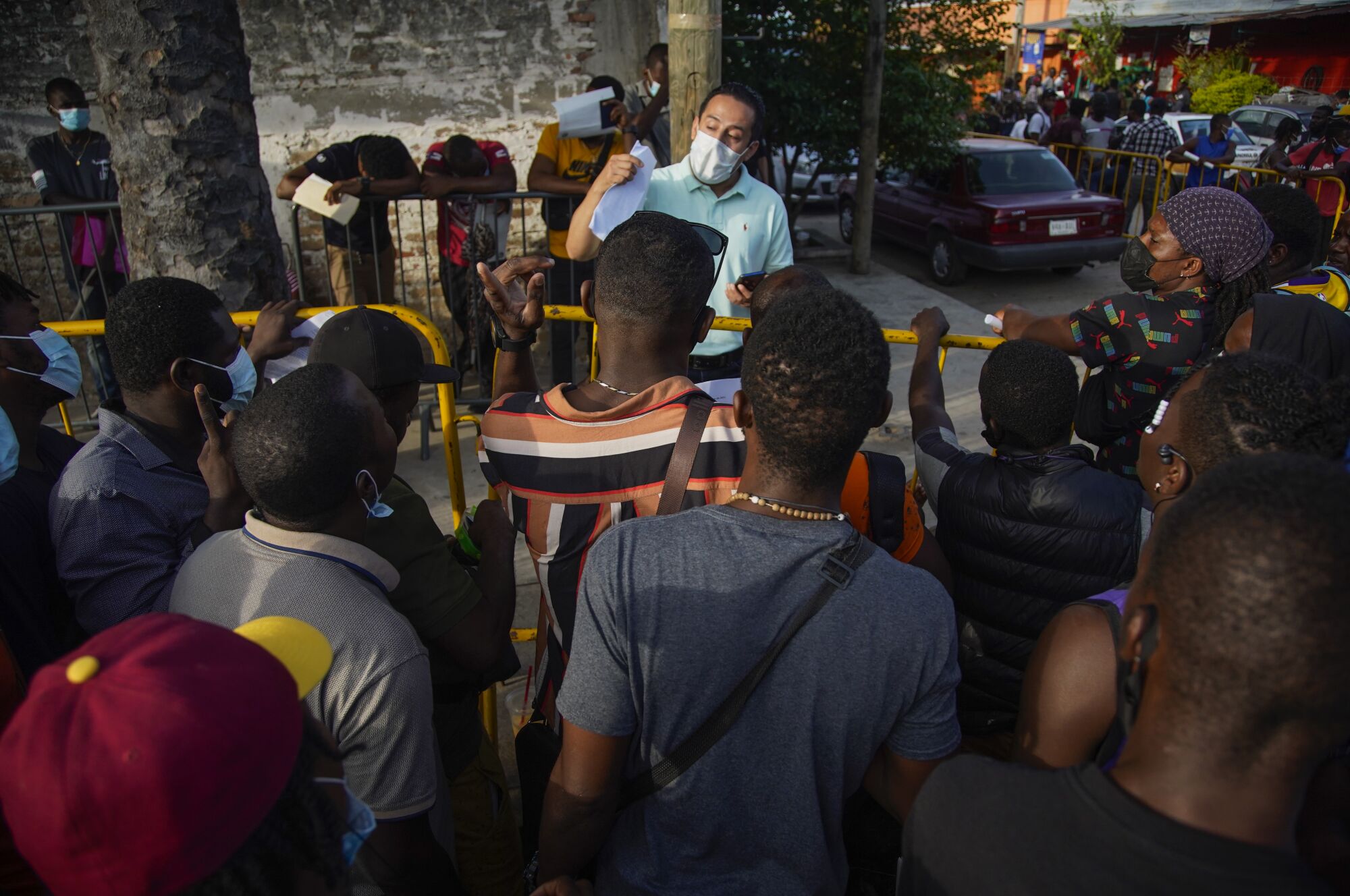 Asylum seekers in Tapachula listen to an official from Mexico's asylum office