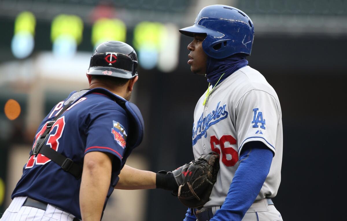 Yasiel Puig is tagged out by Minnesota catcher Josmil Pinto in the first inning of the Dodgers' extra inning victory Thursday over the Twins, 4-3, in the second game of a doubleheader.