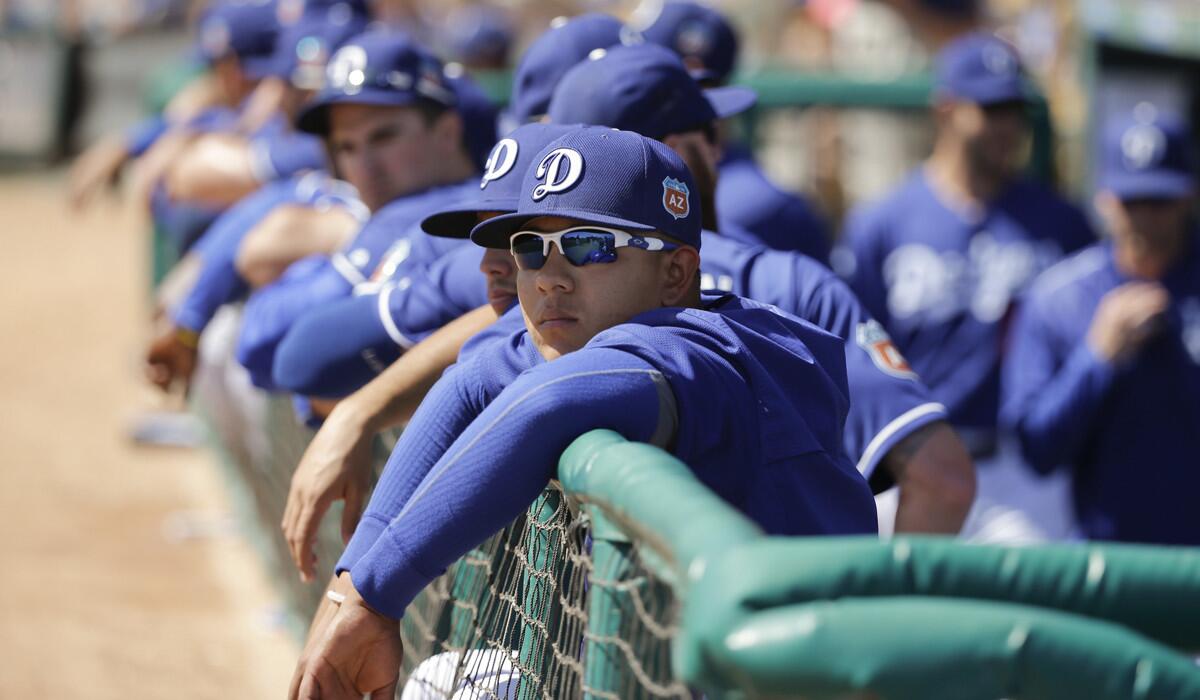Dodgers pitcher Julio Urias, center, watches from the dugout during the team's spring training baseball game against the Milwaukee Brewers in Phoenix on March 14.