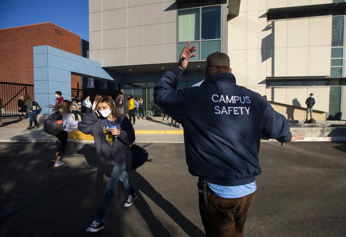 Corey Delahunt, with campus security, directs foot traffic at Corona Del Mar High School.