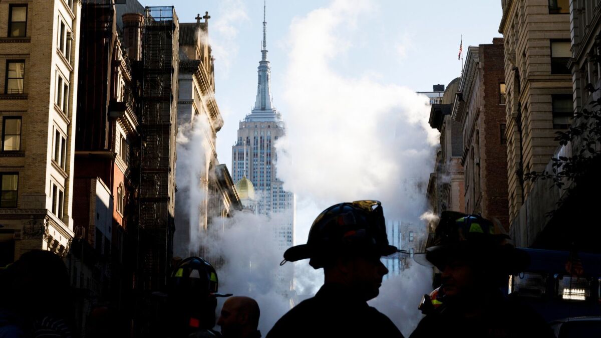 Firefighters work at the scene of a high-pressure steam pipe explosion in New York City.