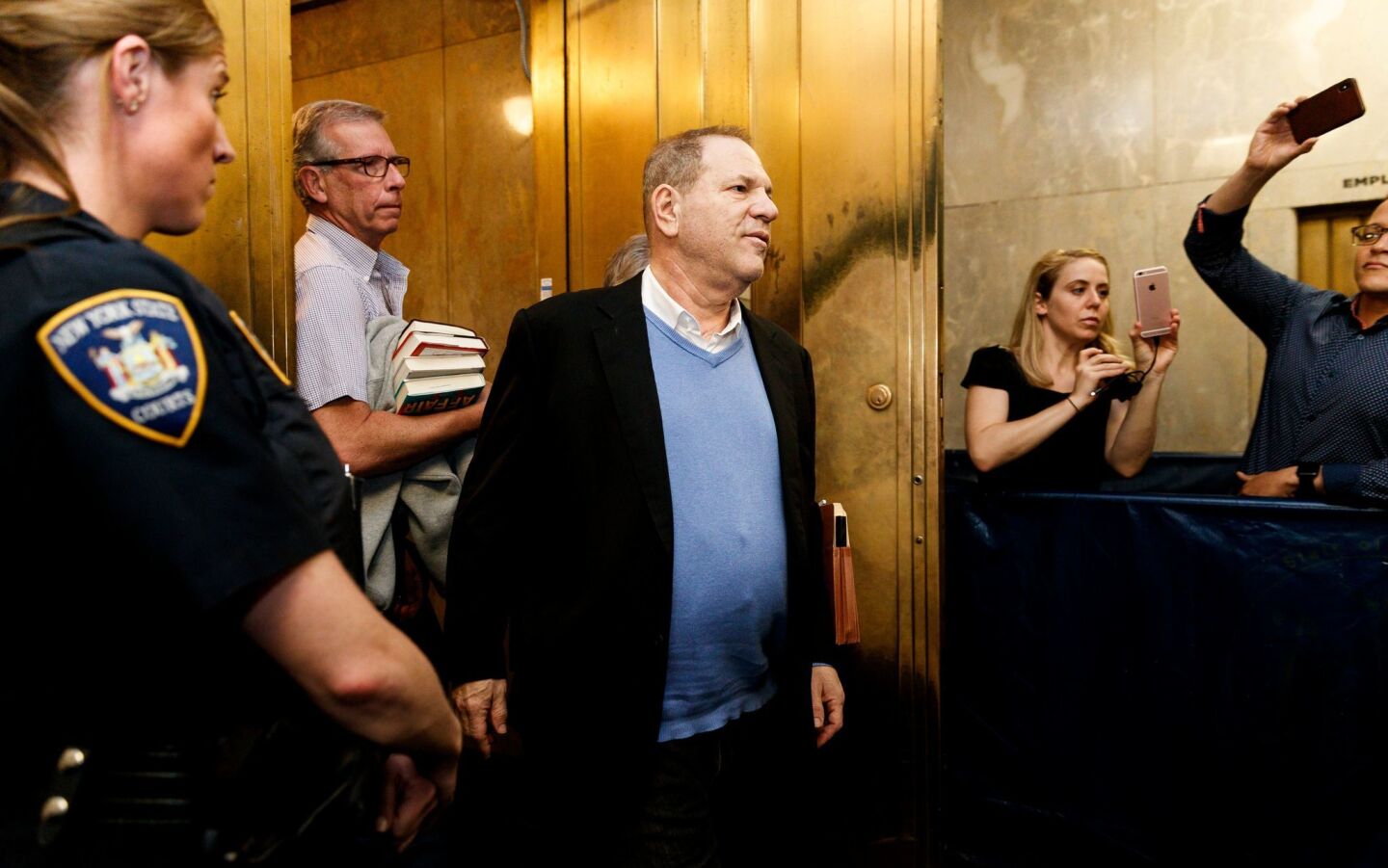 Harvey Weinstein leaves court after being charged with multiple sex crimes in New York.