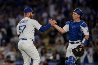 Los Angeles Dodgers relief pitcher Ryan Brasier (57) and catcher Will Smith celebrate the team's win in a baseball game against the Colorado Rockies on Friday, Aug. 11, 2023, in Los Angeles. (AP Photo/Ryan Sun)