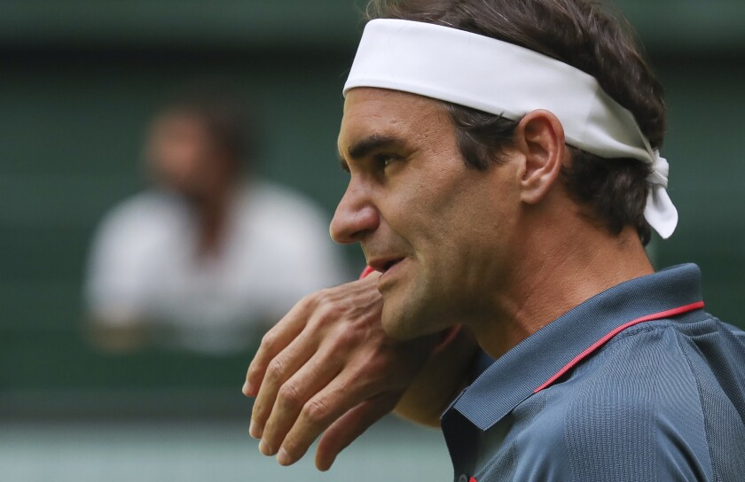 Switzerland's Roger Federer wipes his face during his ATP Tour Singles, Men, Round of 16 tennis match against Canada's Felix Auger-Aliassime in Halle, Germany, Wednesday, June 16, 2021. (Friso Gentsch/dpa via AP)